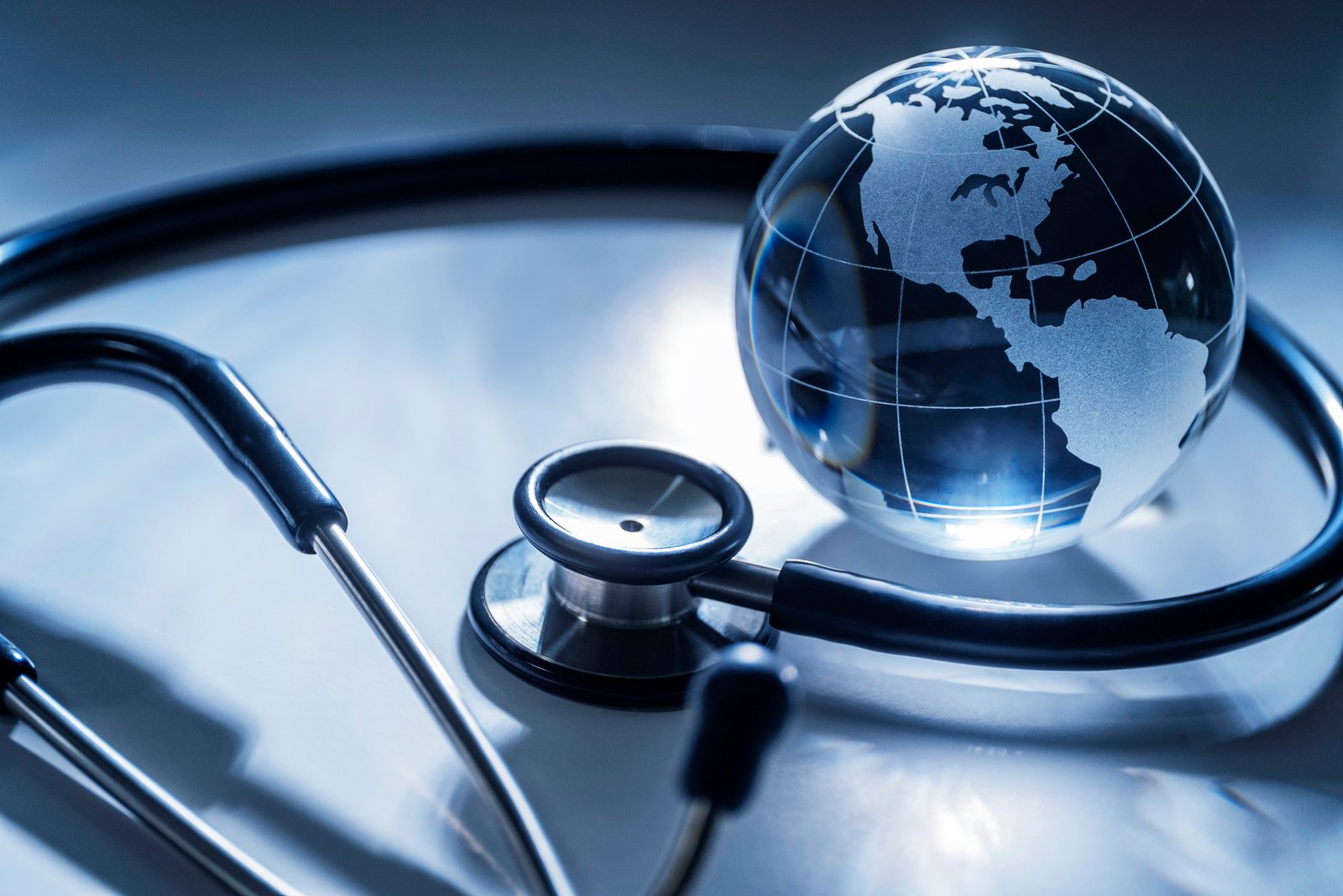 Stethoscope wrapped around a glass globe, representing population health